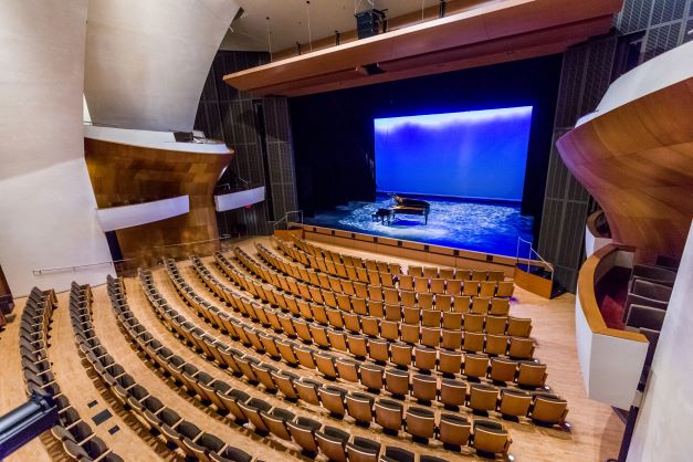 The seats on the ground floor of the BroadStage are gently curved to form an arc facing the stage. There are aisles running down the left and right sides of the room. The aisles slope gently downwards towards the stage and have some deep, low stairs. There are entrances to the auditorium from everal points in the lobby, providing step-free access to each level of seating.